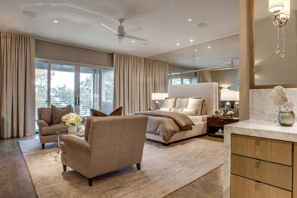 A spacious bedroom featuring a large, light-colored area rug, showcasing the quality products from Dallas Rugs in Dallas, TX.
