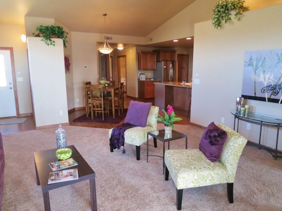 A spacious living room featuring new wall-to-wall carpet installed by Carpet World Fargo, ND