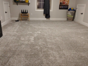 A spacious room with new grey carpet professionally installed by Faith and Grace Flooring in Murfreesboro, TN.