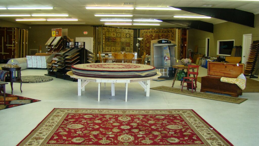 A spacious showroom featuring multiple area rugs and carpet displays at D&D Floors and Moore in Huntsville, AL