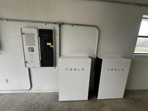 A newly installed SPAN smart electrical panel next to two Tesla Powerwall battery storage units by Volt-Pro Electric, LLC in Houston, TX