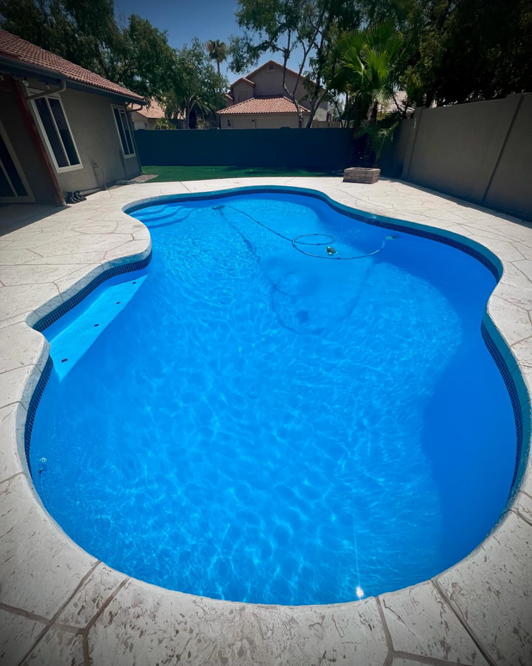 A sparkling clean, blue residential swimming pool after professional service by The Pool Service Pros in New Hill, NC.