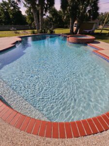 A sparkling clean residential swimming pool with a small attached spa, showcasing the quality service of La Pool Pro LLC in New Orleans, LA.