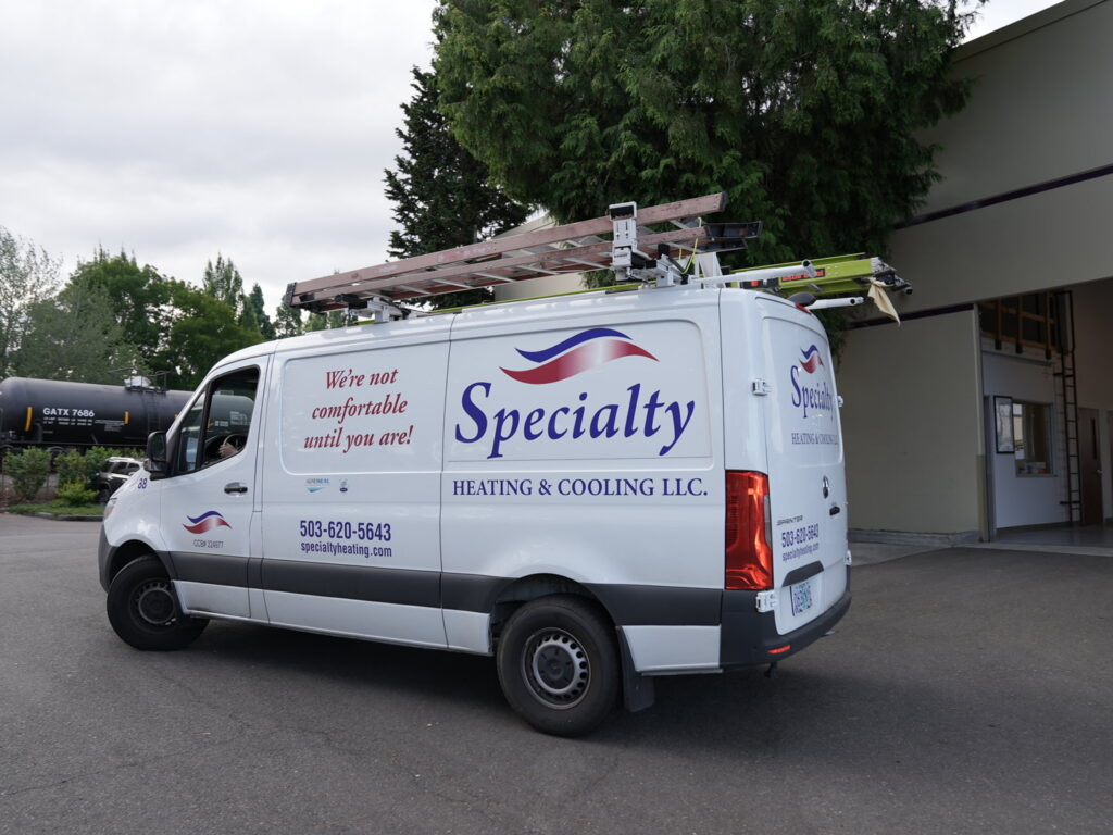 A Specialty Heating and Cooling service van with ladders on the roof in Portland, OR.