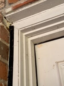 Daddy long-legs spiders and webs on a door frame, showing pest issues for EcoShield Pest Solutions Fort Worth, TX.