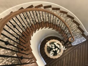 An elegant patterned carpet runner installed on a spiral staircase by Carpet Binding Company in Charlotte, NC.