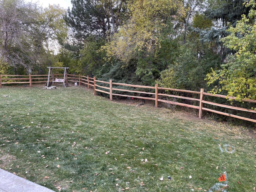 A rustic split-rail fence lining a spacious backyard, expertly installed by North CO Fence & Deck in Greeley, CO.