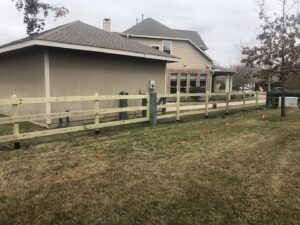 A newly installed split rail fence with wire mesh in a residential yard by GOAT Fence Company in Houston, TX.