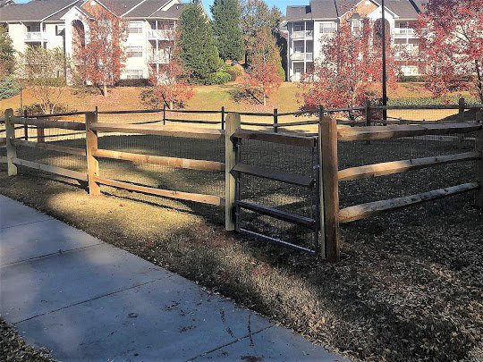 A split-rail fence with wire mesh and a small gate installed by United Fence Company in Johnston, RI.