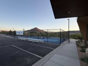 A wide view of sports courts with a black chain-link fence and mountains in the background by Legacy Fencing LLC in St. George, UT.