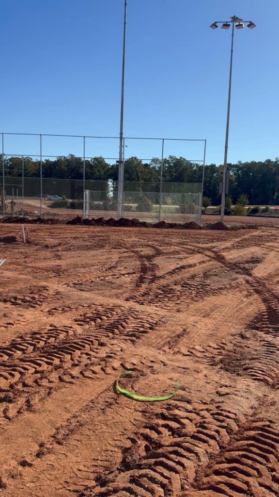 A chain-link fence installed around a sports field by Hawk Fences LLC in Johns Creek, GA, providing boundary and safety.
