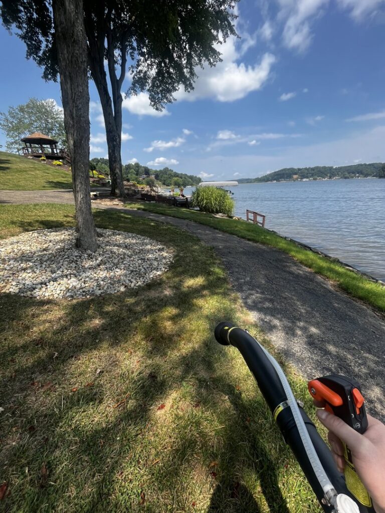 A Nature Spray Organics employee spraying grass along a waterfront property in East Canton, OH.