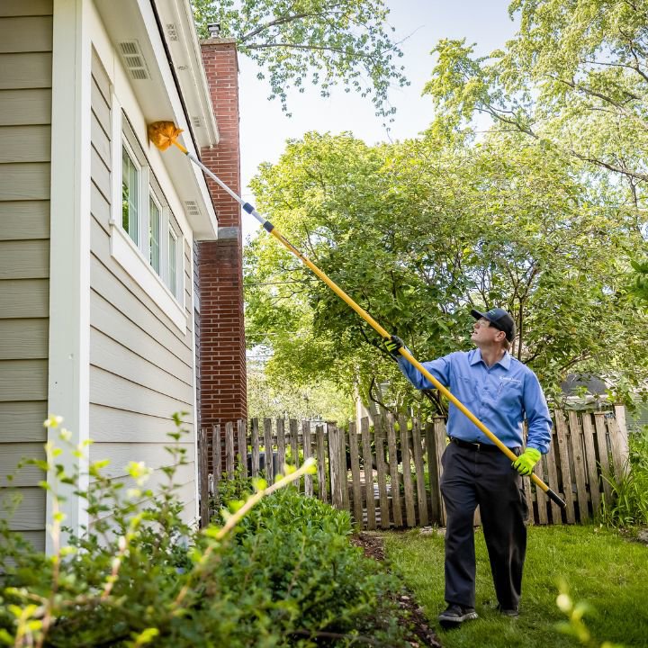 A SpringGreen technician treating the eaves of a house for pest control in Tussville, AL.