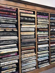 A large stack of colorful, intricately patterned rugs in the Organic Looms showroom in Scottsdale, AZ