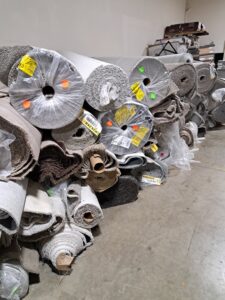 A large stack of various rolled carpets, ready for installation by Truly Carpet in Cleveland, OH.