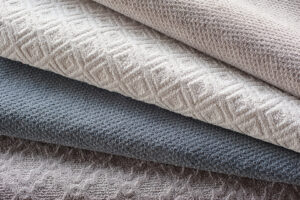 A close-up view of a stack of various carpet samples available at Junge's Flooring in Rochester, MN