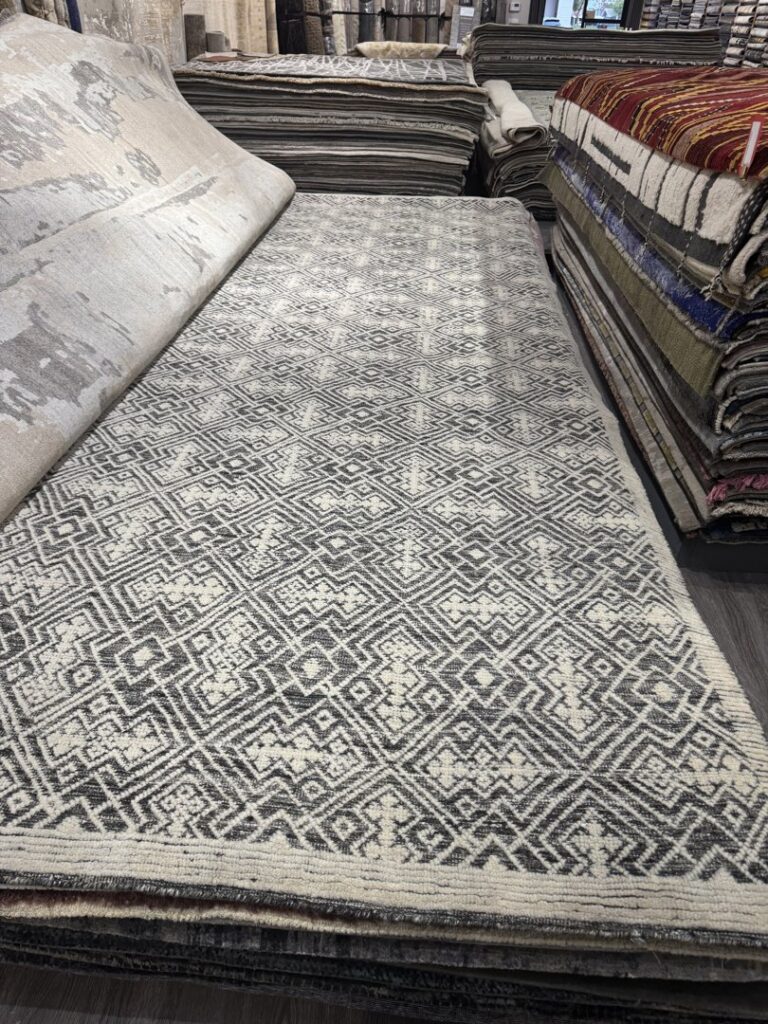 A neatly stacked display of various patterned rugs in the Organic Looms showroom in Scottsdale, AZ