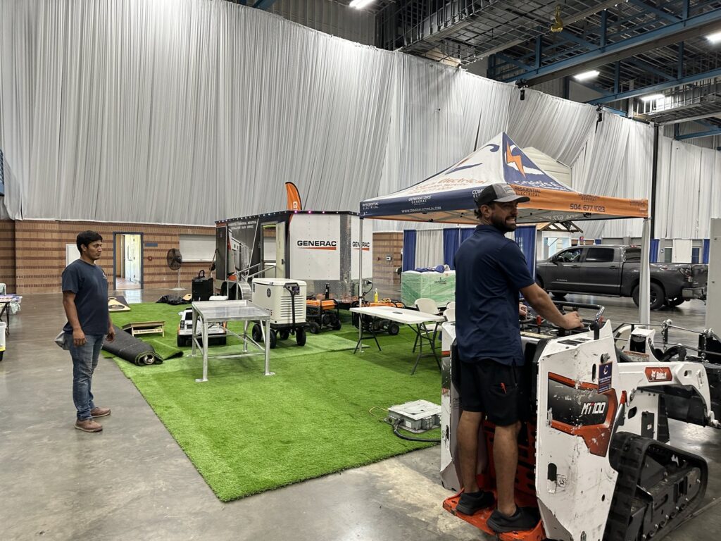 Staff members standing next to a Generac generator display at a trade show for Craig's Electrical and Generator Service in Kenner, LA.