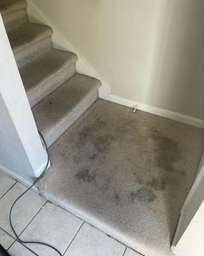 Heavily stained carpeted landing area before professional cleaning by D&A Carpet Cleaning in Durham, NC.