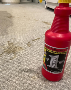 Stained carpet with organic stain remover bottle, ready for cleaning by Dirt Blasters Carpet Cleaning Inc. in Atlanta, GA
