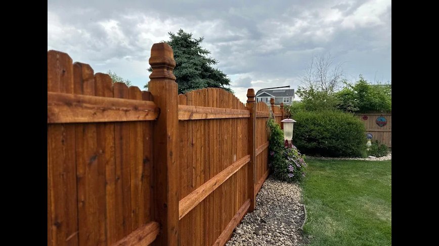 A stained wood fence with decorative post caps installed by Cedar Mountain Fence Company in Plainfield, IL.