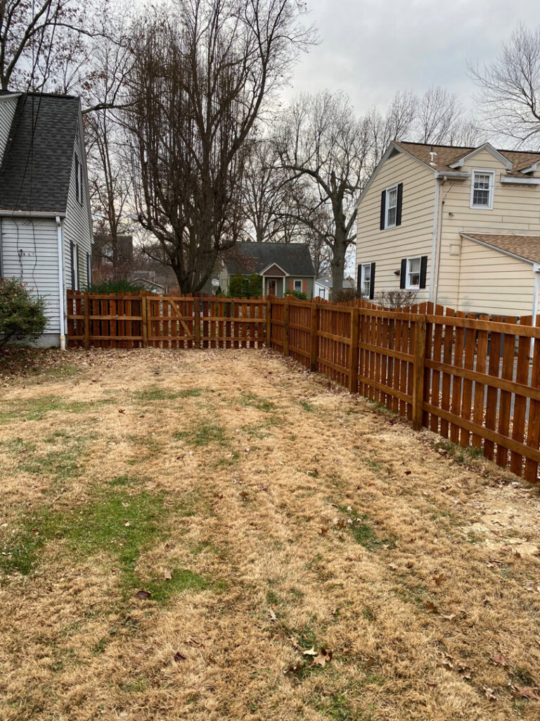 A beautifully stained wood privacy fence in a residential backyard by ACE and Sons Fence Company in Evansville, IN.