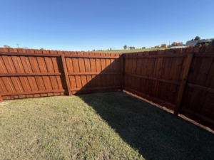 A corner section of a stained wood privacy fence installed by Quality Deck & Fence LLC in Owensboro, KY