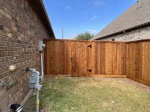A beautifully stained wood privacy fence with a double gate, expertly installed by Fence Builders of Houston, TX.