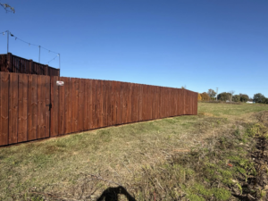 A newly installed stained wood privacy fence with a gate by Quality Deck & Fence LLC in Owensboro, KY