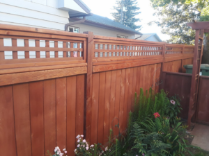 A beautifully stained wooden privacy fence with a decorative lattice top installed by The Best Fence Company in Spokane, WA.