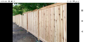 A long, stained wooden privacy fence providing security and aesthetic appeal, built by McDaniels Fencing in Huntington, WV.