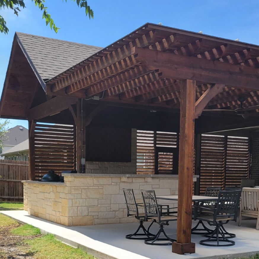 A beautifully stained wooden privacy fence with two gates installed in a backyard by Ft Worth Fence And Patio in Fort Worth, TX.