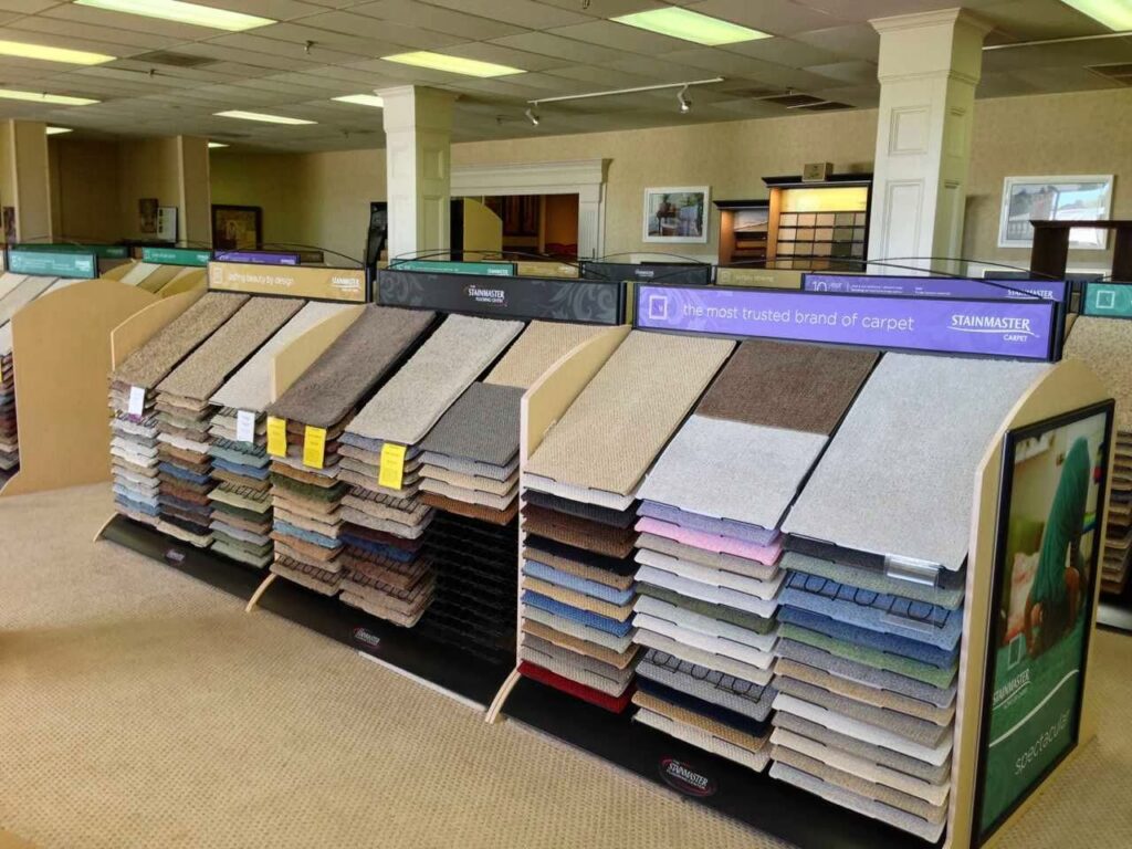 Stainmaster carpet samples displayed on racks in the showroom at Jimmie Lyles Flooring Gallery in Flowood, MS
