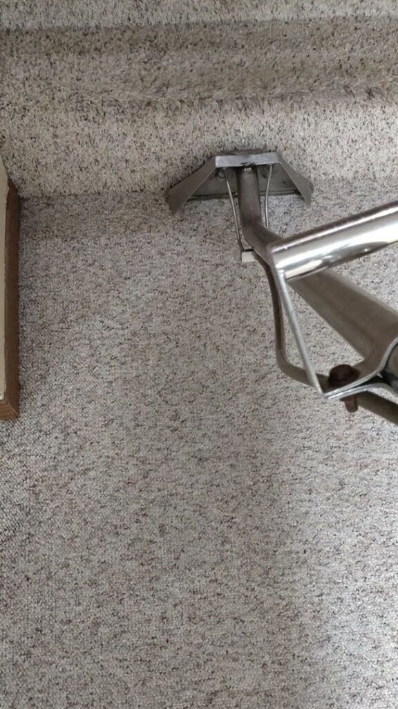 A carpet cleaning tool being used to clean a carpeted staircase by Norris Carpet Care in Watertown, SD.