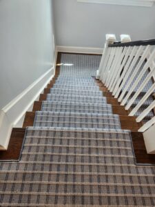 A blue plaid carpet runner expertly installed on a residential staircase by Carpet One Floor & Home Denver in Denver, CO.