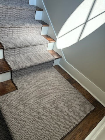 A newly installed light grey patterned carpet runner on a staircase by Elite Flooring America in Decatur, AL.
