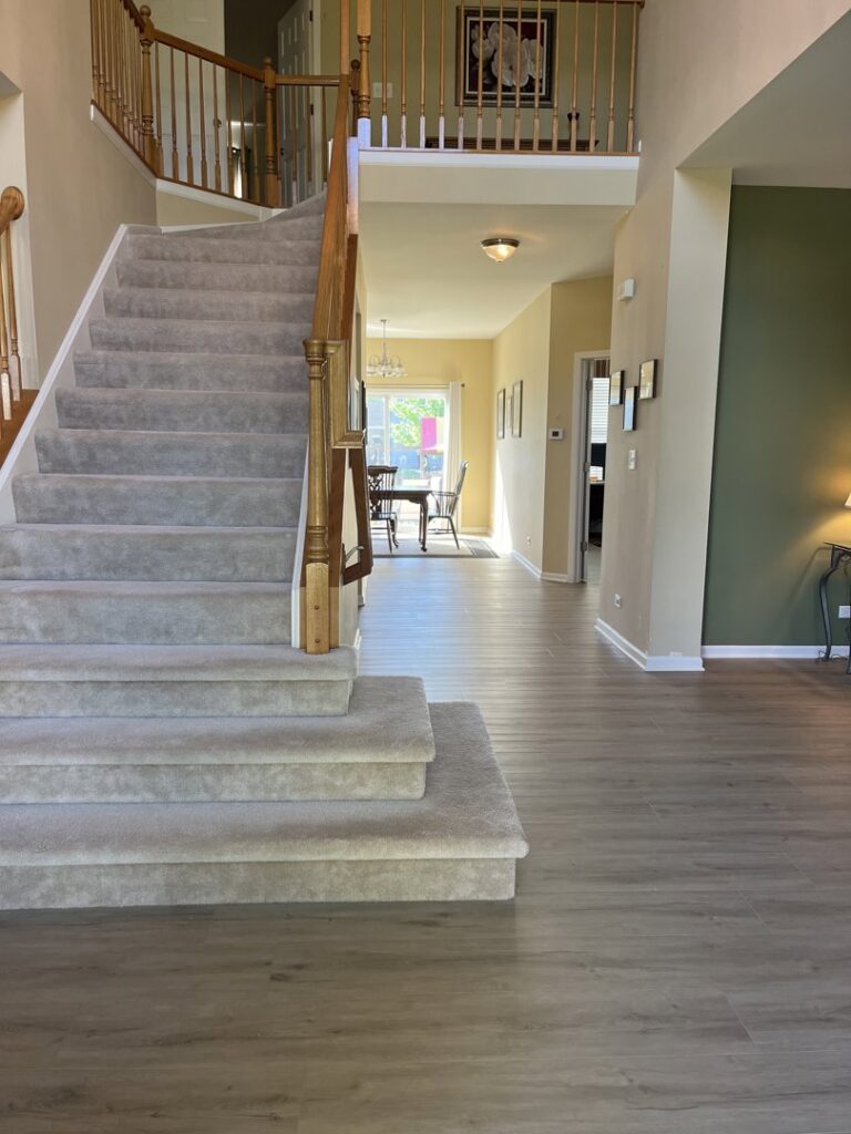 A grand staircase featuring a newly installed carpet runner by Great Northern Flooring in Bensenville, IL.