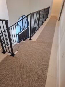 A beige patterned carpet runner installed on a staircase by Palmetto Carpet Company in Miami, FL.