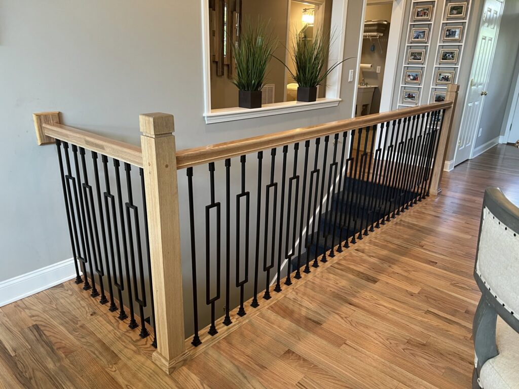 A dark carpet runner installed on a residential staircase by Mastercraft Wood Flooring in Loudon, TN