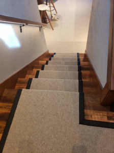 A view down a staircase featuring custom carpet runners installed by Altered Edge in Kalispell, MT