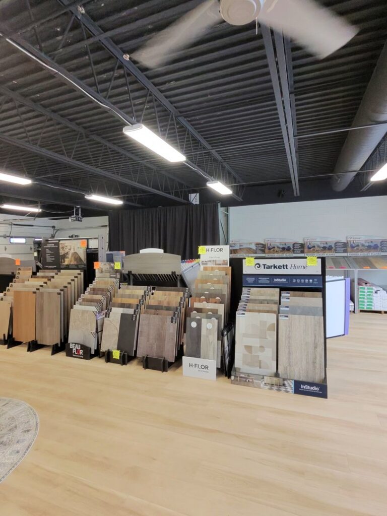 A staircase and landing with new grey carpet and black railing installed by PerfectStep Flooring Solutions in Rochester, NY.