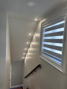 Recessed lighting installed along a sloped ceiling above a staircase by Electric R US LLC in Dearborn, MI.