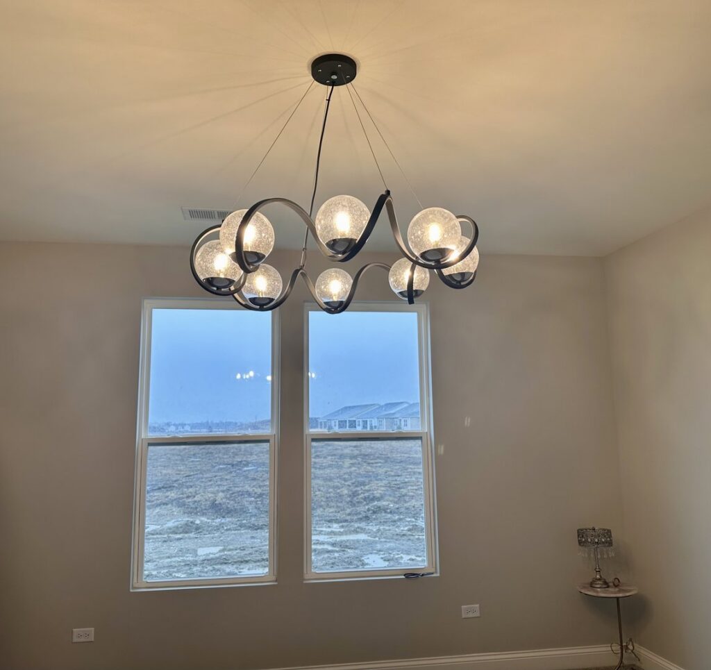 Elegant stairwell with a modern chandelier lighting fixture installed by VIP Electrical Services in Naperville, IL.