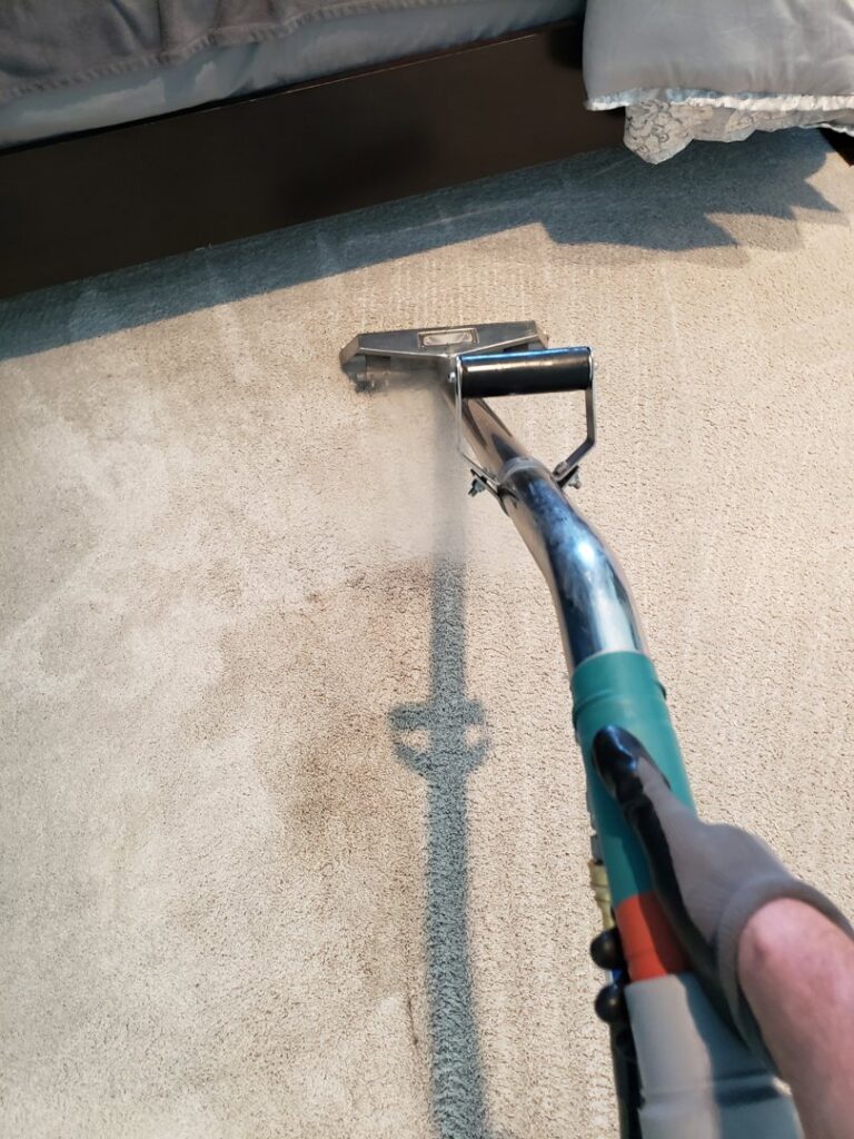 A close-up of a steam carpet cleaning wand in action, removing dirt from a carpet by Steamaway Carpet Cleaning in Albuquerque, NM.