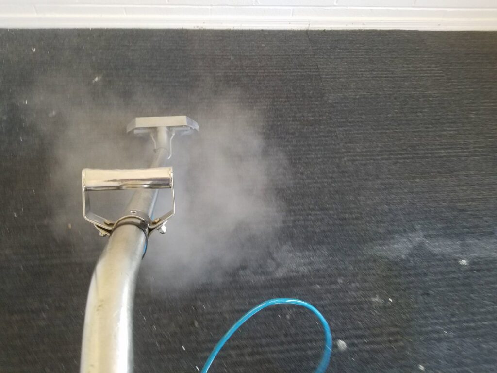 Steam carpet cleaning in progress on a dark carpet by Regal Carpet Cleaning Inc. in Tucson, AZ