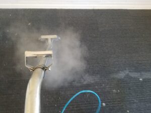 Steam carpet cleaning in progress on a dark carpet by Regal Carpet Cleaning Inc. in Tucson, AZ