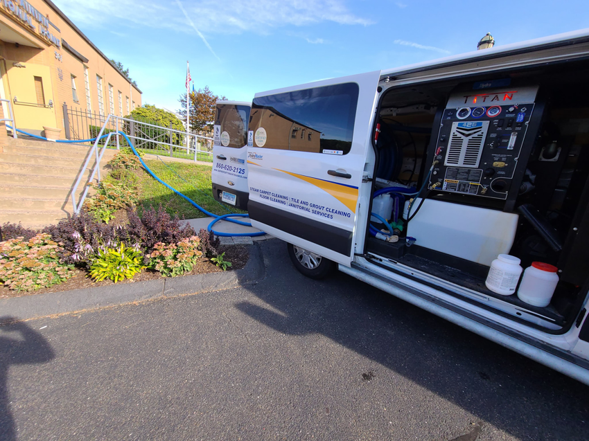 A B&H Property Maintenance LLC van with steam carpet cleaning equipment and hoses ready for a job in Middletown, CT.