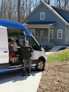 A Steam Giant technician standing proudly next to the branded service van at a job site in Raleigh, NC.