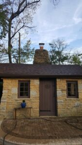 A well-maintained stone chimney on a small building by Centerville Pipestone Chimney Services LLC in Dayton, OH.