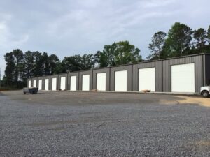 A row of storage units with newly installed white roll-up garage doors by Magic City Door Huntsville in Birmingham, AL.